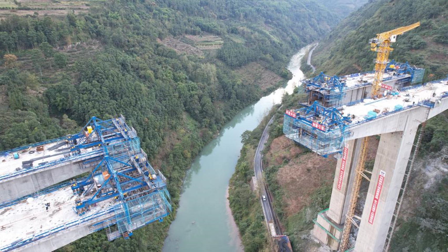 The Mabian River Bridge under construction with cantilever carriages and suspension baskets